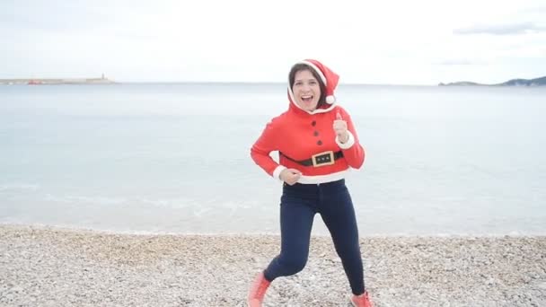 Allegro giovane donna in cappello di Babbo Natale ballare all'aperto — Video Stock