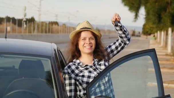 Молодая женщина держит ключ от новой машины — стоковое видео