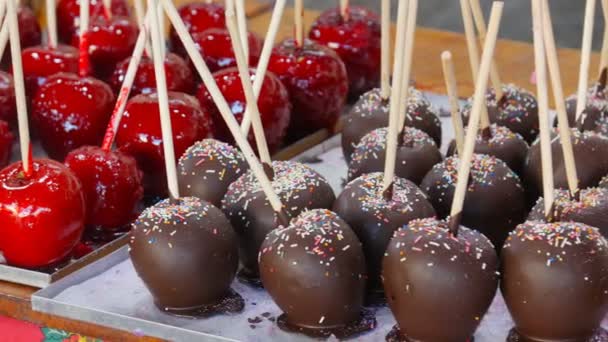 Manzanas de caramelo en chocolate y nueces. Comida callejera — Vídeo de stock