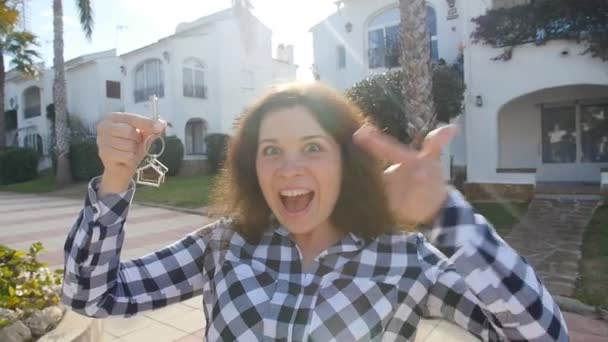 Joyeux jeune femme emménageant dans une nouvelle maison. Affichage des clés de nouvelle propriété — Video