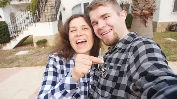 Hausbesitzer mit Schlüssel-Selfie. Immobilien, neues Haus oder Wohnung und Personenkonzept — Stockvideo