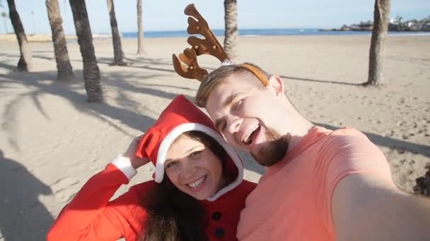 Ευτυχισμένο ζευγάρι εικόνα Χριστούγεννα selfie για διακοπές στην παραλία — Αρχείο Βίντεο
