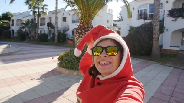 Ευτυχισμένος νεαρή γυναίκα με το καπέλο santa λήψη selfie — Αρχείο Βίντεο