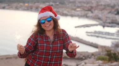 Mutlu kadın bir maytap ateşle dans. Noel kavramı