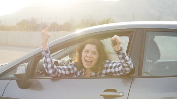 彼女の新しい車に満足して笑顔の車のキーを示す女性ドライバー — ストック動画