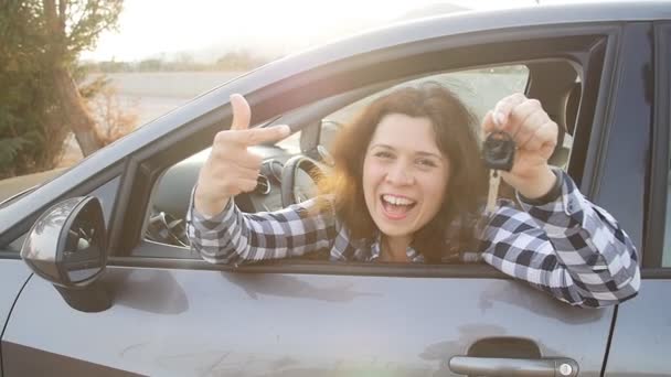Mujer conductor mostrando las llaves del coche sonriendo feliz en su nuevo coche — Vídeo de stock