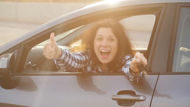 Женщина водитель показывает ключи от машины улыбаясь счастливо в своей новой машине — стоковое видео