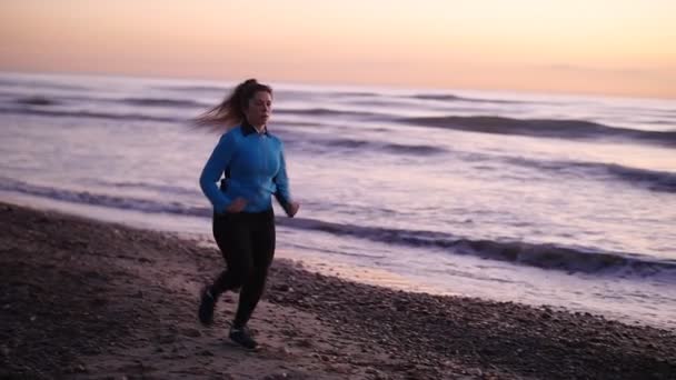 フィットネス女性ランナー、ビーチを走る — ストック動画