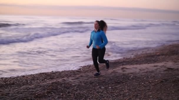 Фітнес жінка біжить на пляжі — стокове відео