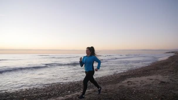 Fitness woman runner running on the beach — Stock Video