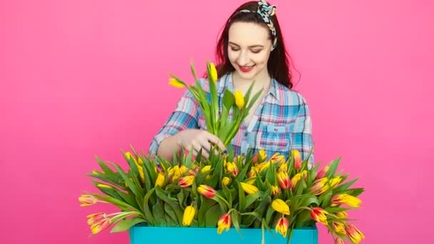 Young female florist with big box of yellow tulips — Stock Video