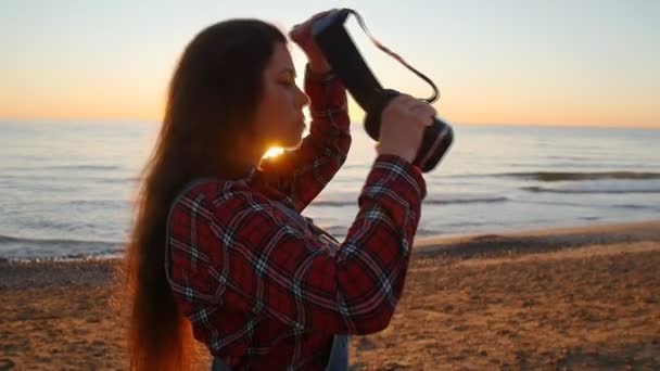 Mulher jovem usa óculos de realidade virtual ao pôr do sol — Vídeo de Stock