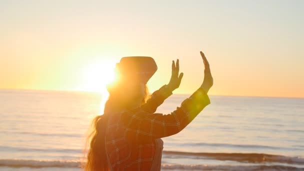 Mulher jovem usa óculos de realidade virtual ao pôr do sol — Vídeo de Stock