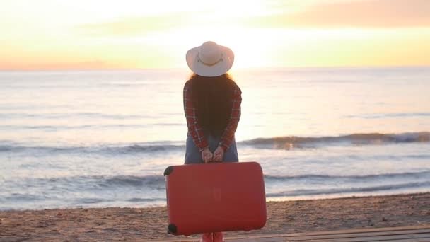在海滩上带着手提箱散步的年轻女子 — 图库视频影像