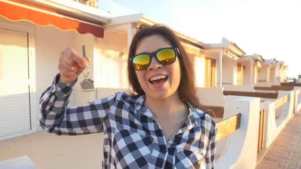 Šťastná usmívající se žena drží klíče od domu jejího nového domu — Stock video