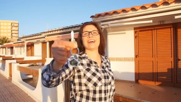 Boldog mosolygó nő tartja az új házát a lakáskulcsokat — Stock videók