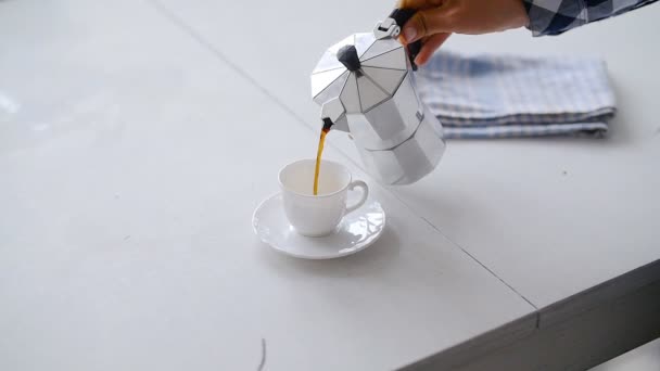 Mano vertiendo café de un Moka Pot. Mesa blanca — Vídeos de Stock