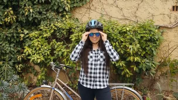 Giovane donna con una bicicletta su una strada di città — Video Stock