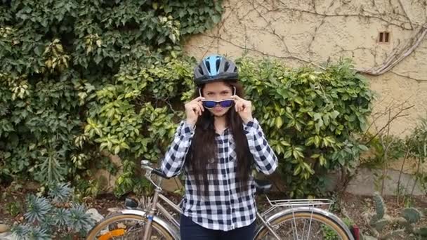 Νεαρή γυναίκα με ένα ποδήλατο σε ένα δρόμο της πόλης — Αρχείο Βίντεο