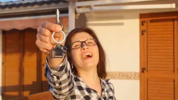 Gelukkig jonge vrouw met nieuwe huis sleutels outdoors — Stockvideo
