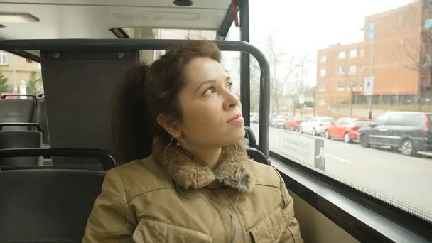 Молодая женщина в автобусе смотрит в окно — стоковое видео