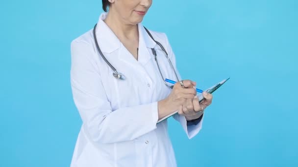 Sorrindo médico mulher sobre fundo azul — Vídeo de Stock