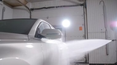 Genç kadın yıkar araba ile yüksek basınçlı yıkama makinesi