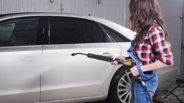 Jonge vrouw wast auto met hogedruk wasmachine — Stockvideo