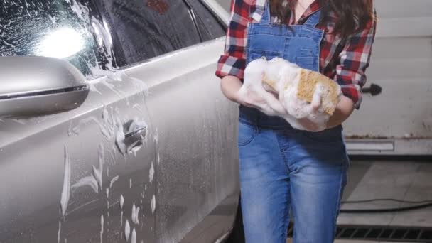 Jovem mulher lavando um carro com uma esponja — Vídeo de Stock