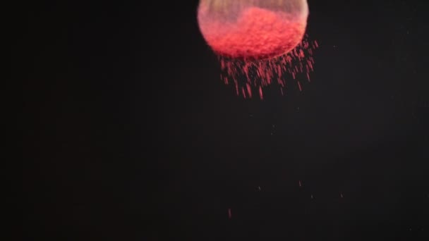 Cepillo de maquillaje con polvo rosa sobre fondo negro — Vídeo de stock