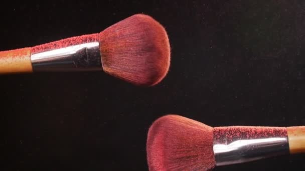 Cepillo de maquillaje con polvo rosa sobre fondo negro — Vídeos de Stock