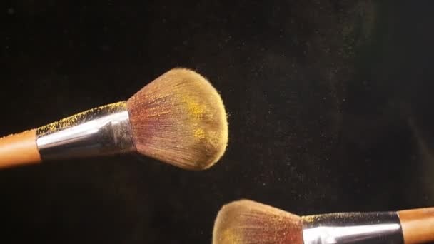 Brosse cosmétique avec poudre dorée sur fond noir — Video