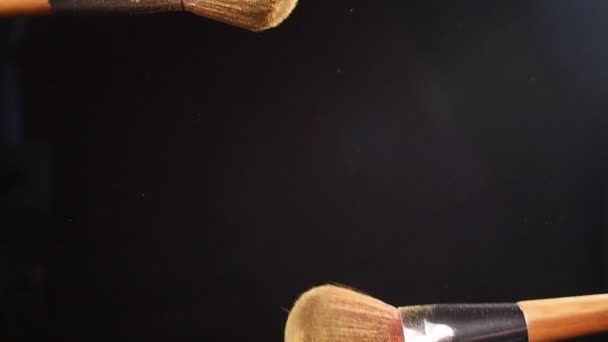 Brosse cosmétique avec poudre dorée sur fond noir — Video