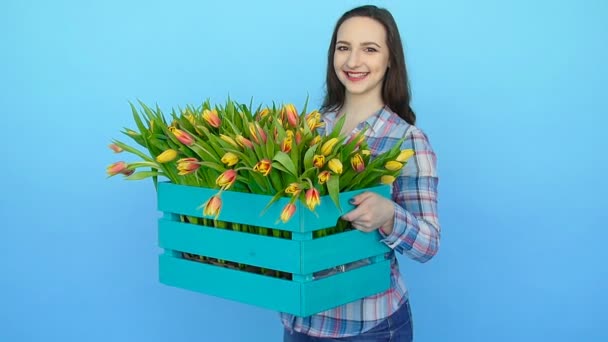 Mladá žena držící krabici čerstvé kvetoucí tulipány — Stock video