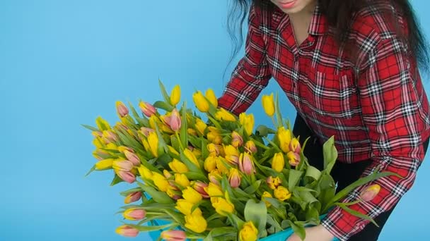 Květinářství veselá mladá žena držící pole tulipánů