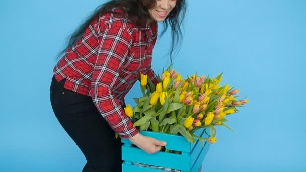 Glad ung kvinna florist håller låda med tulpaner — Stockvideo