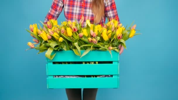 Fröhliche junge Floristin hält Schachtel mit Tulpen — Stockvideo