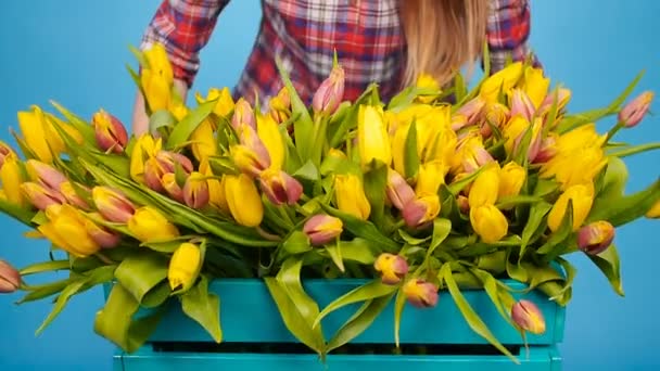 Joven florista alegre sosteniendo caja de tulipanes — Vídeos de Stock