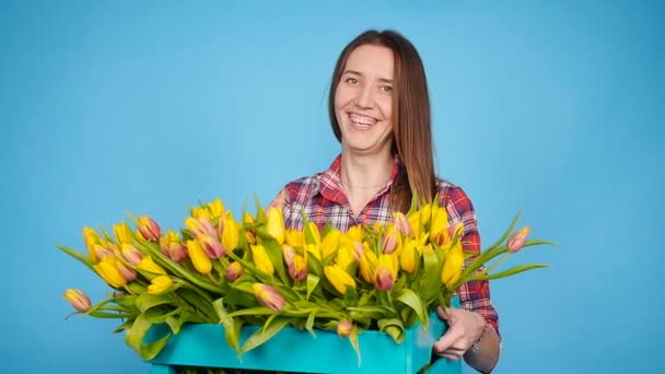 Joyeux jeune femme fleuriste tenant boîte de tulipes — Video