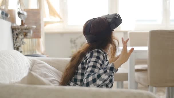 Mujer joven usando auriculares de realidad virtual — Vídeos de Stock