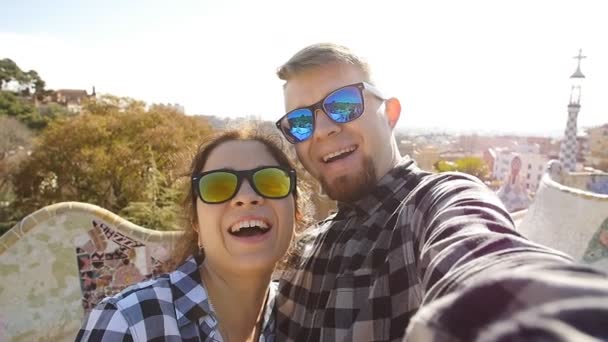 旅行夫妇愉快地谈论自拍自画像与智能手机在公园奎, 巴塞罗那, 西班牙 — 图库视频影像