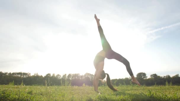 Concetto di salute, stretching e stile di vita sano. Giovane atleta femminile seduta su un esercizio e stretching in un parco al tramonto . — Video Stock