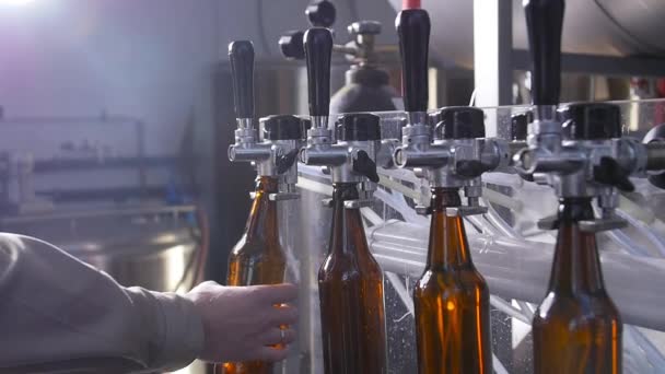 Piccole imprese e concetto di produzione. Riempimento di bottiglie di birra in birreria — Video Stock