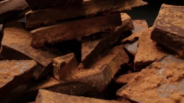 Stukken chocolade bestrooid met cacao — Stockvideo