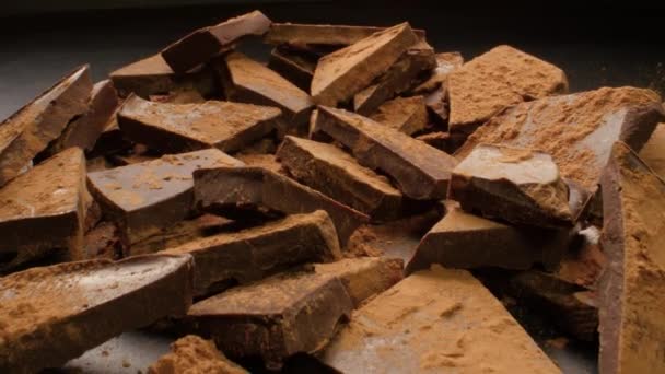 Pedazos de chocolate espolvoreados con cacao — Vídeos de Stock