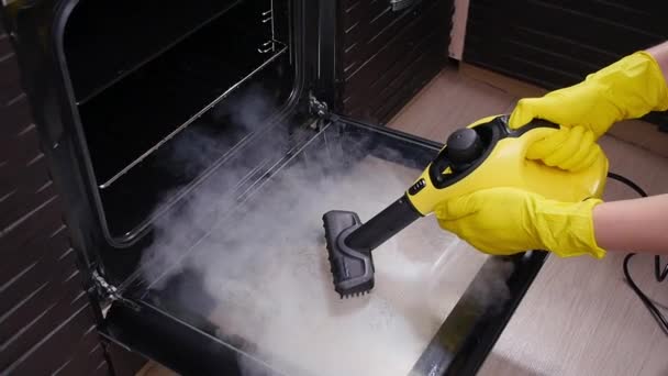 Koncepcja sprzątania domu. Mężczyzna sprzątanie kuchni z odkurzaczem parowym — Wideo stockowe
