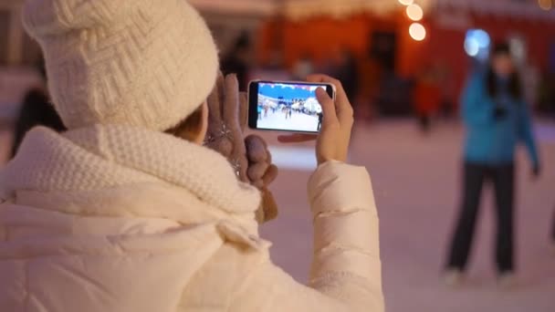 スマートフォンでヨーロッパのクリスマスマーケットの写真を撮る幸せな女性 — ストック動画