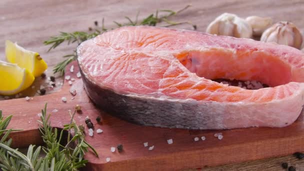 Meeresfrüchte und Kochkonzept. frisches rohes Lachssteak mit Gewürzen — Stockvideo