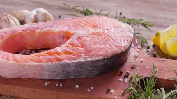 Meeresfrüchte und Kochkonzept. frisches rohes Lachssteak mit Gewürzen — Stockvideo