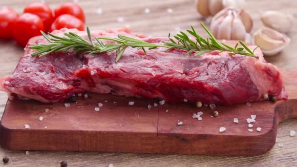 Steak de bœuf cru sur une table en bois — Video